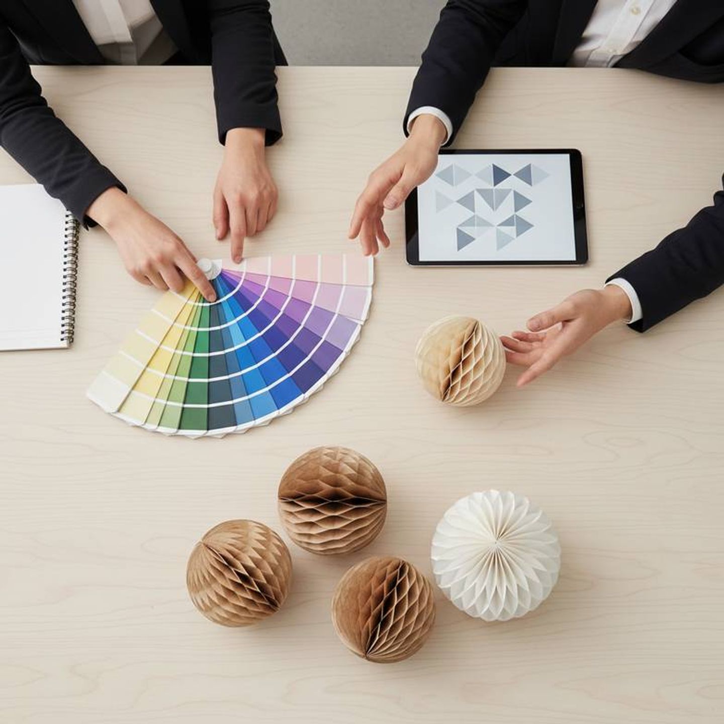 A designer reviewing paper color swatches with a manufacturer's representative.