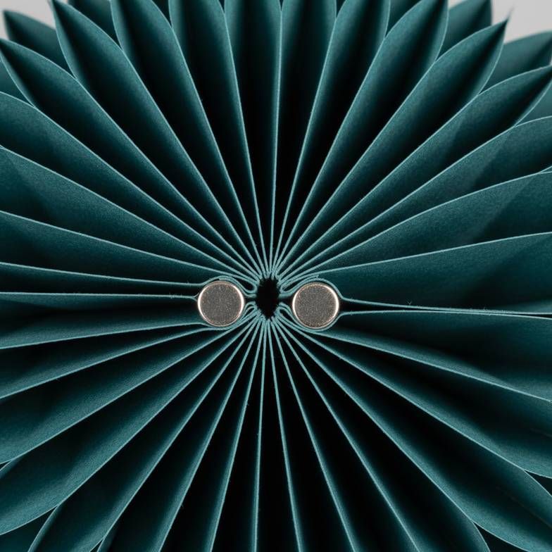 Close-up of the magnetic closure on a foldable honeycomb paper decoration.