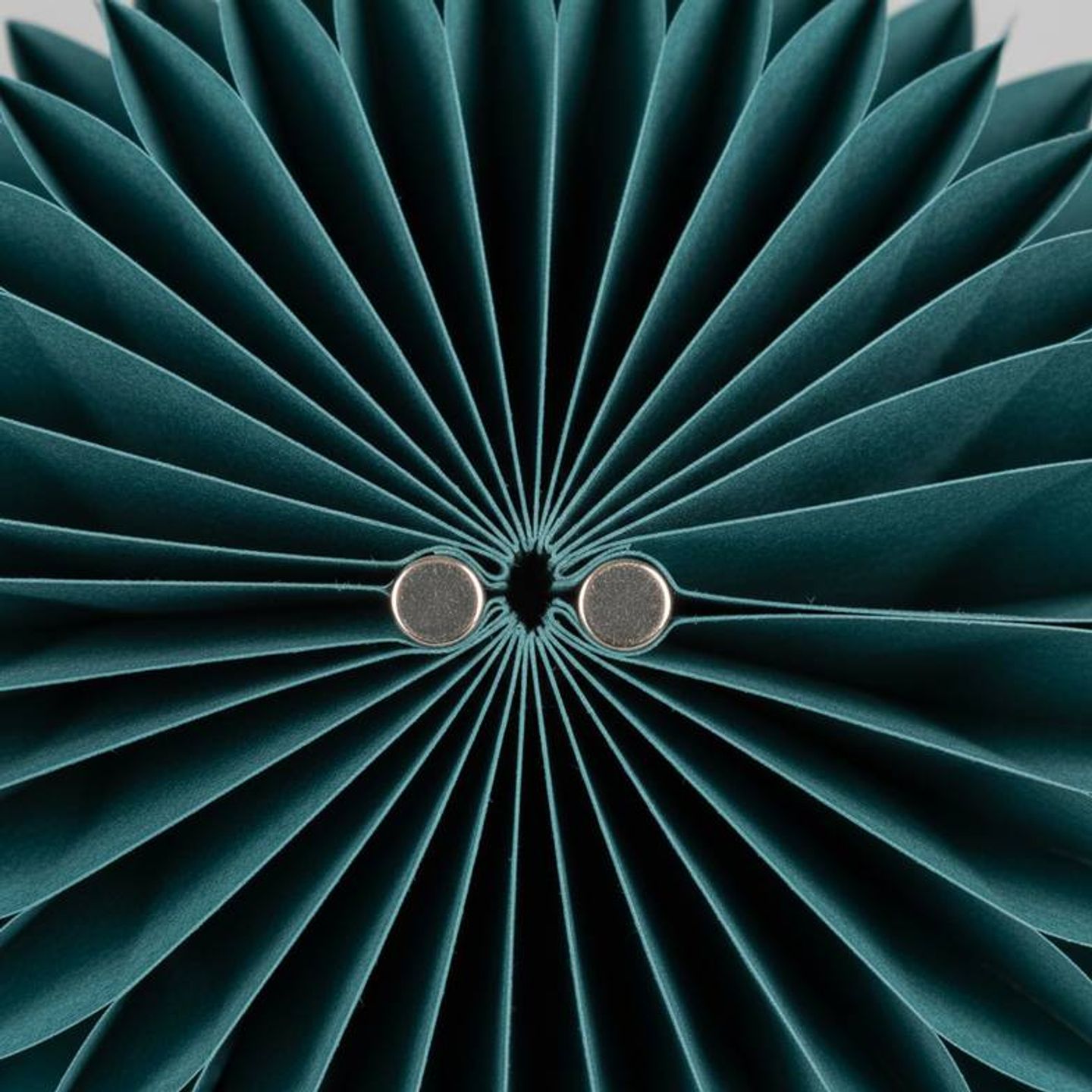 Close-up of the magnetic closure on a foldable honeycomb paper decoration.
