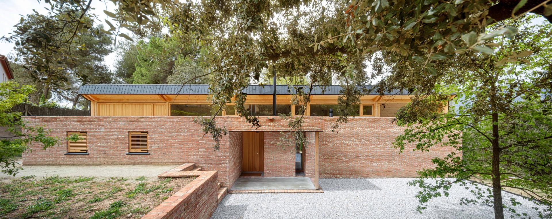Vista de l’accés a la façana de la Casa GE a Osona amb estructura de maó