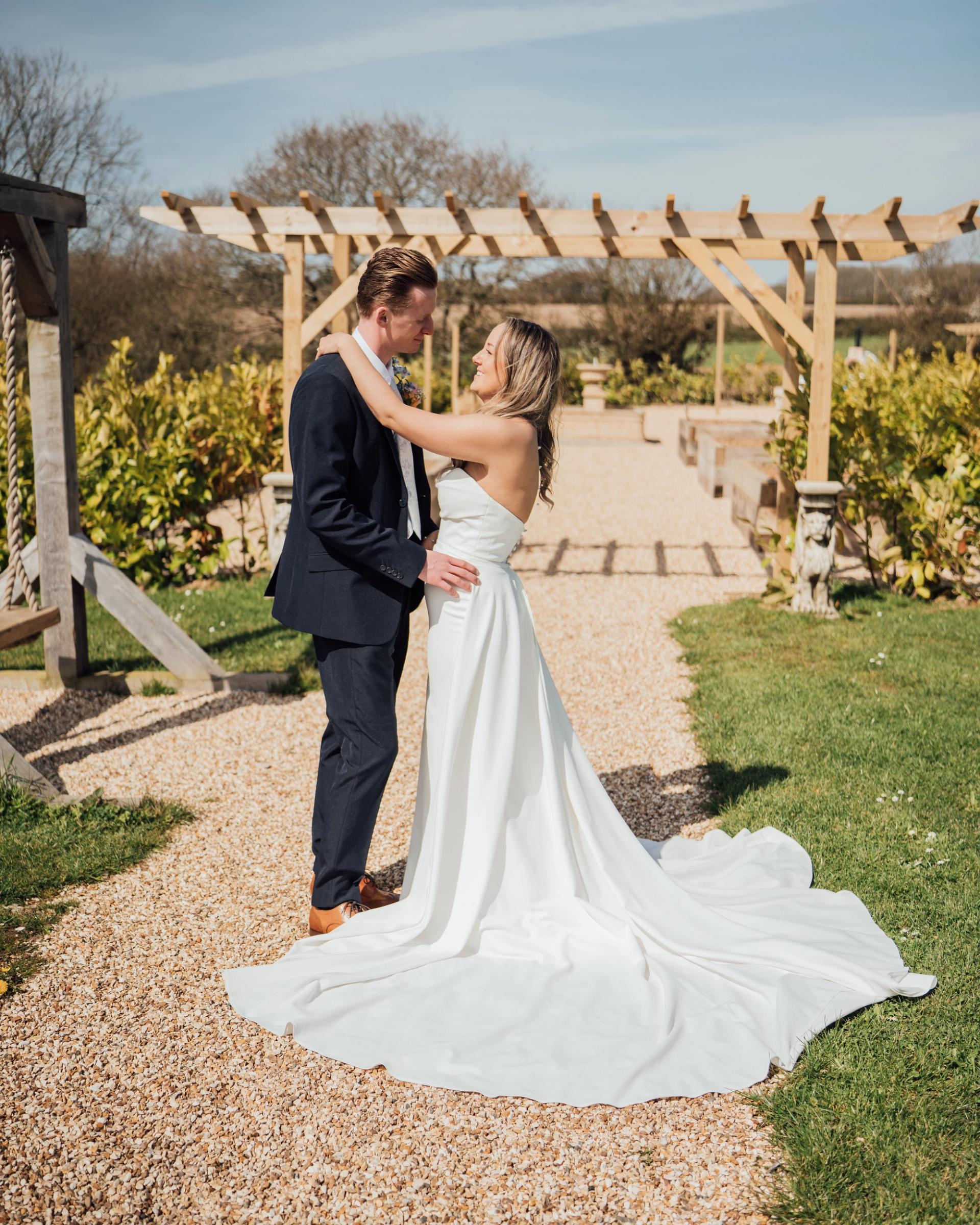 Married couple standing in front of the pergola in the kitchen garden