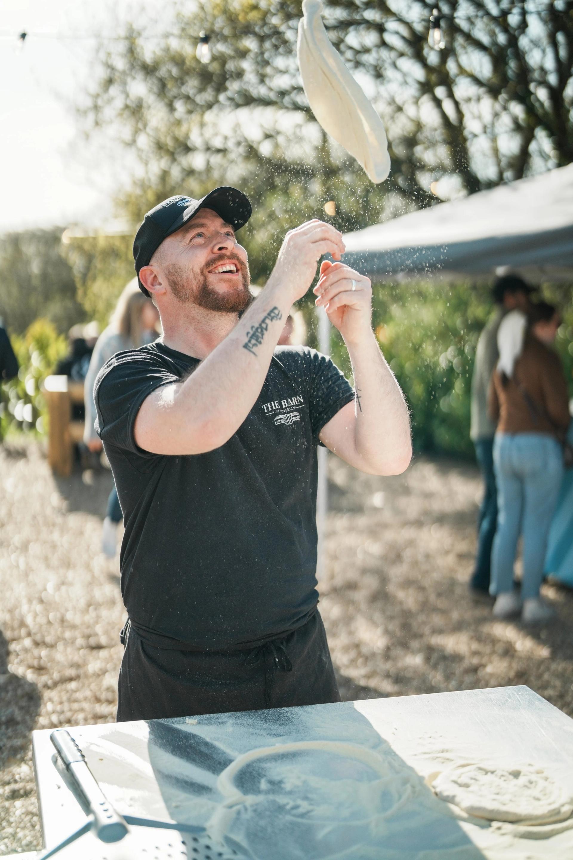 The chef flinging the pizza base into the air