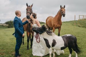 Bride and Groom holding onto horses and a pony