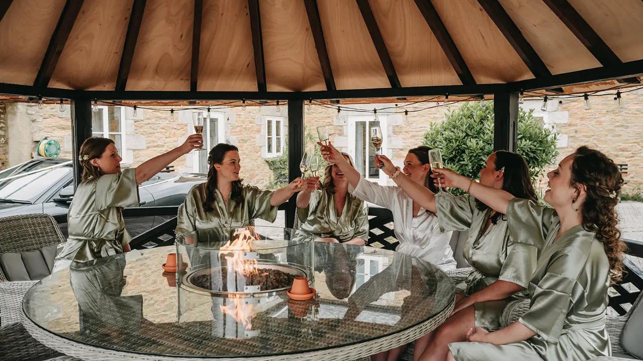 The bridal party raising their glasses in the courtyard