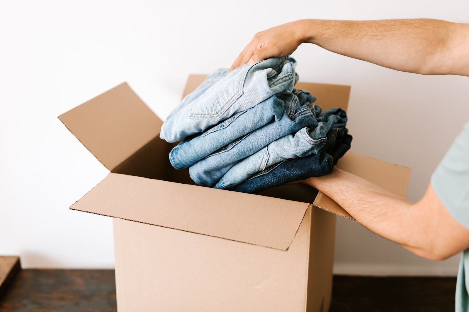 A picture of an ecommerce business owner packing a small box to ship items.