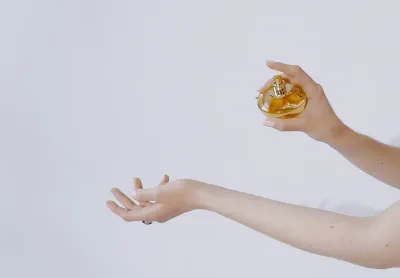 Perfume being sprayed onto a woman's wrists