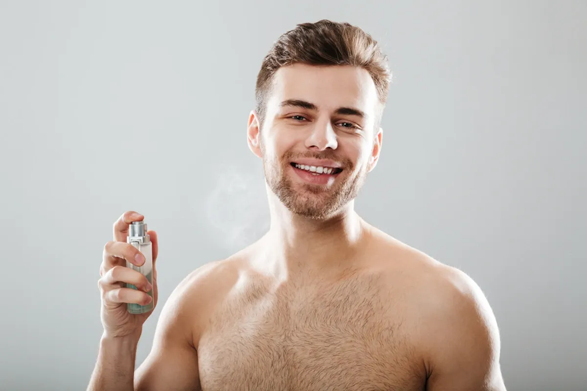 Man spraying his neck with perfume