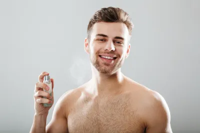 Man spraying his neck with perfume