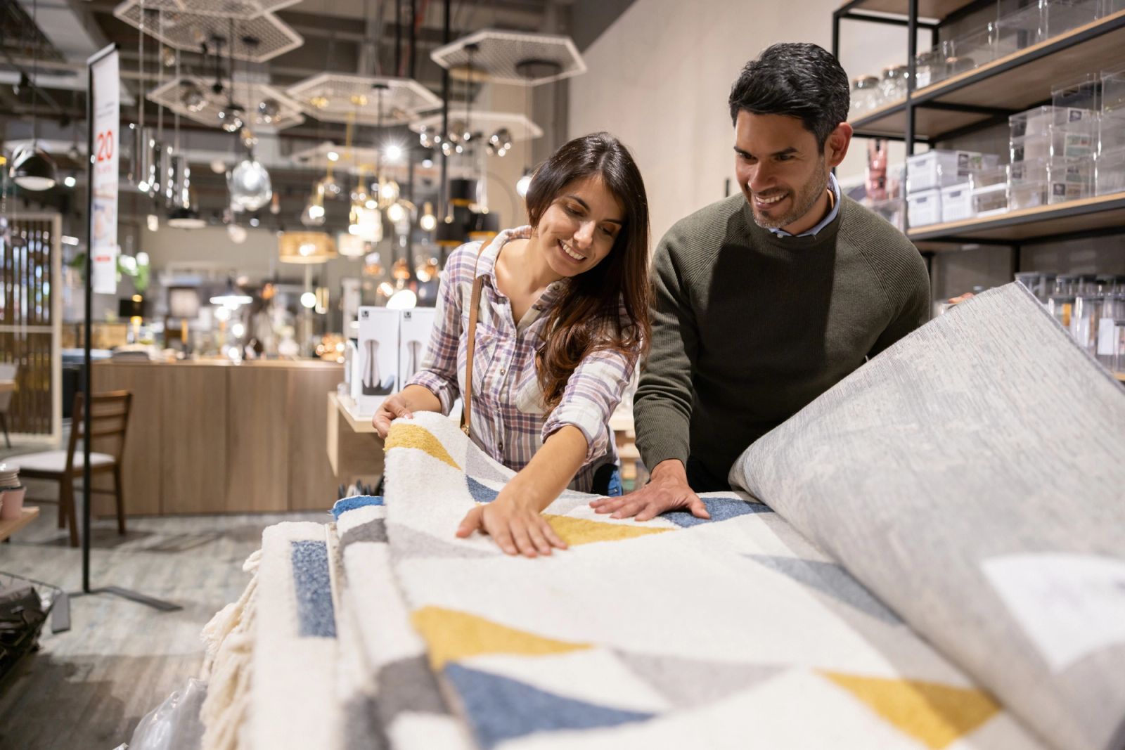 Couple shopping for area rugs in a local furniture showroom, comparing quality and patterns