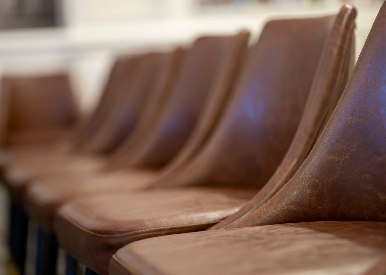 Row of floor model dining chairs displayed in a furniture showroom
