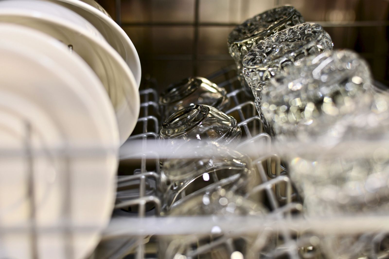 Dishwasher floor model on display with clean dishes and glassware inside