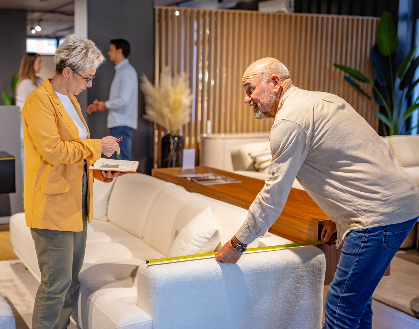 Customers working with a local furniture retailer to choose a sofa in a showroom, highlighting personalized in-store service and hands-on shopping.