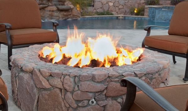 Outdoor stone fire pit with seating, creating a warm backyard gathering space