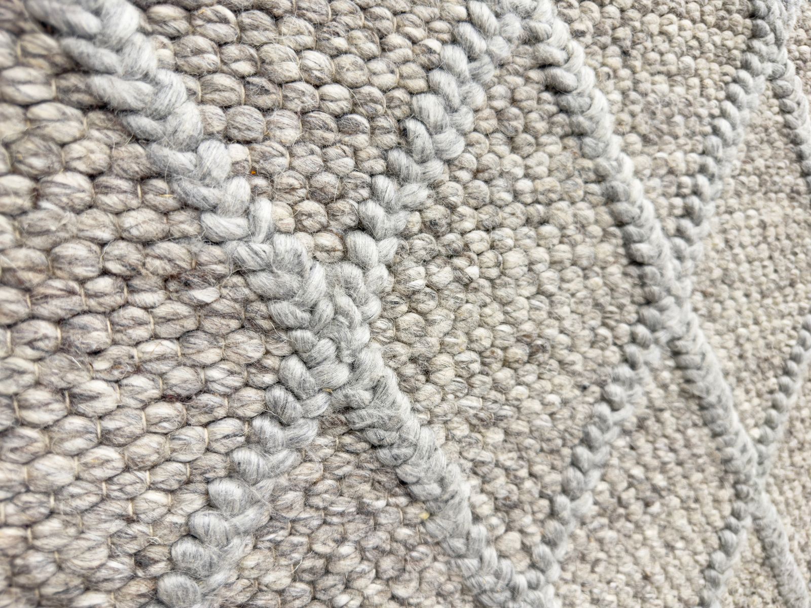 Close-up view of textured carpet flooring with soft fibers and neutral tones.