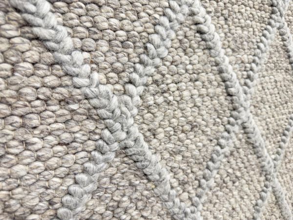 Close-up view of textured carpet flooring with soft fibers and neutral tones.