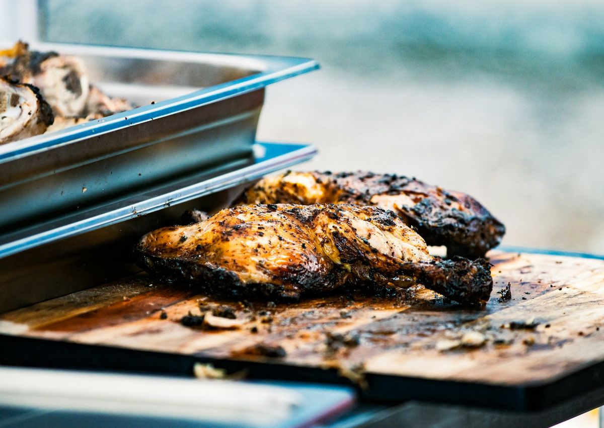 Oven-jerked chicken thighs with charred, blistered edges on a roasting rack