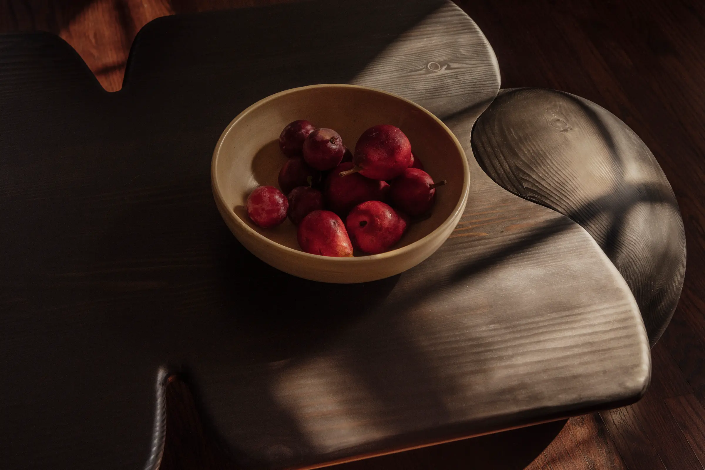 Dark wood table with bowl of pears on it