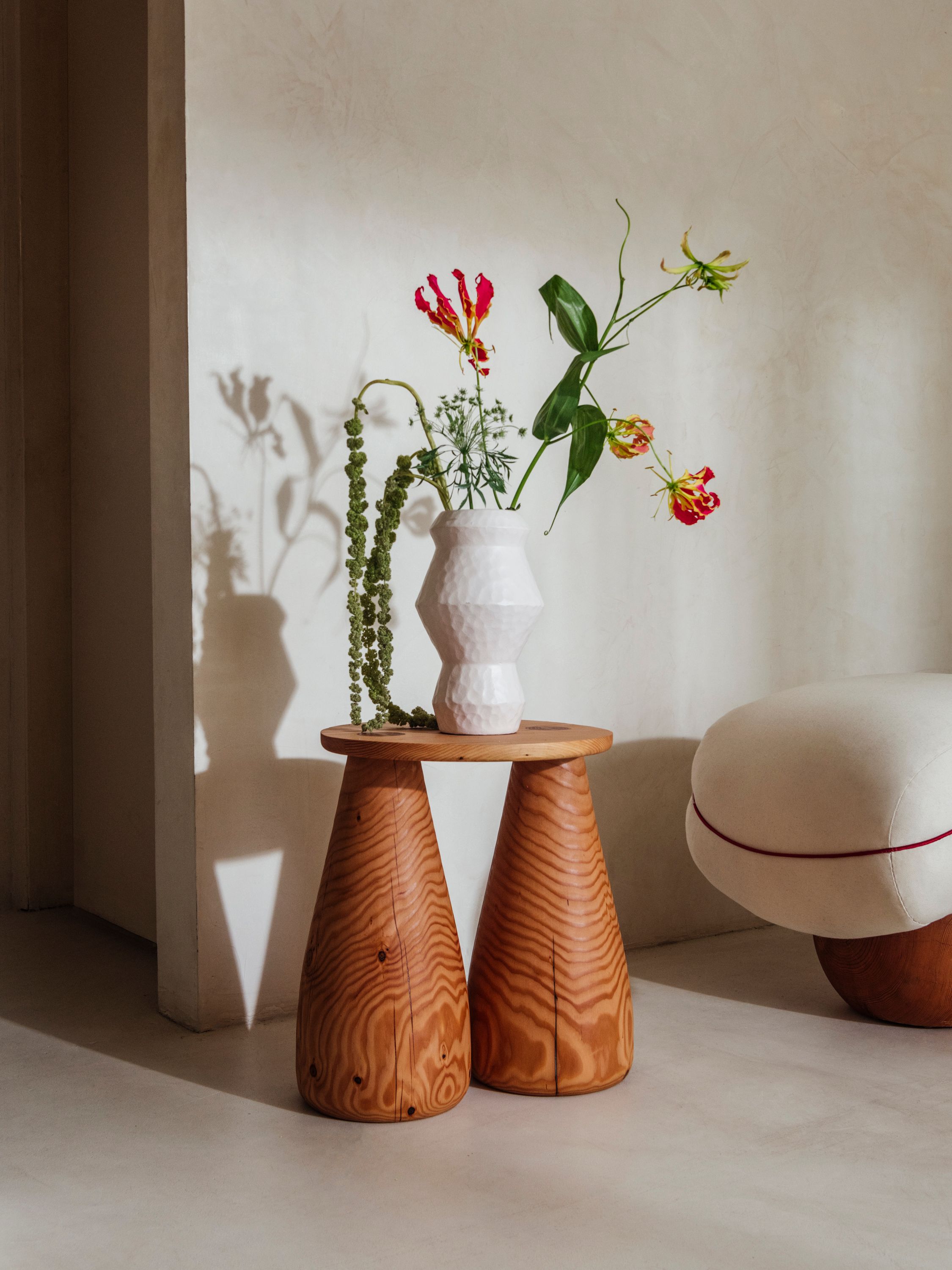 A wooden side table with sculpted legs and a round top.