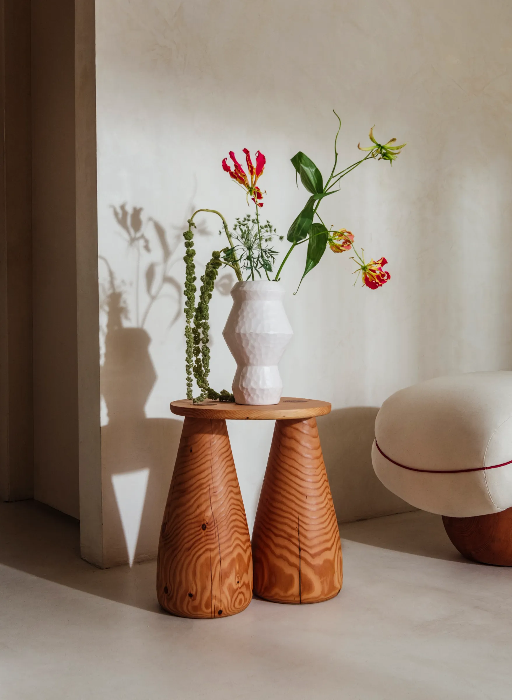 A wooden side table with sculpted legs and a round top.