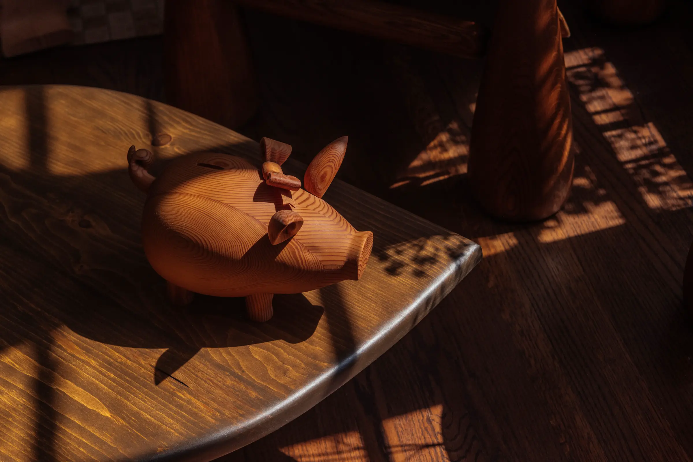 Wood pig on wood table with shadows