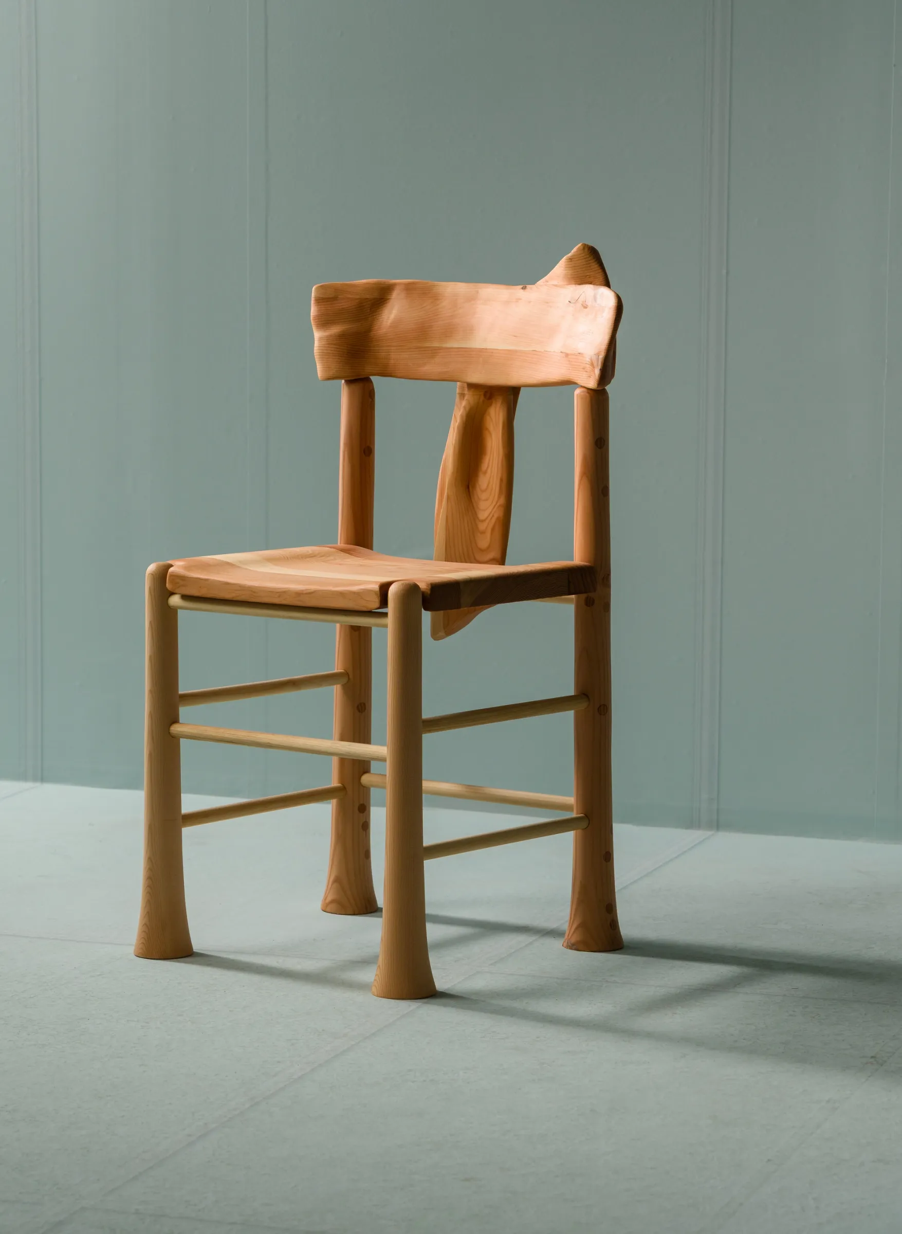 angled front view of trumpet dining chair on blue background