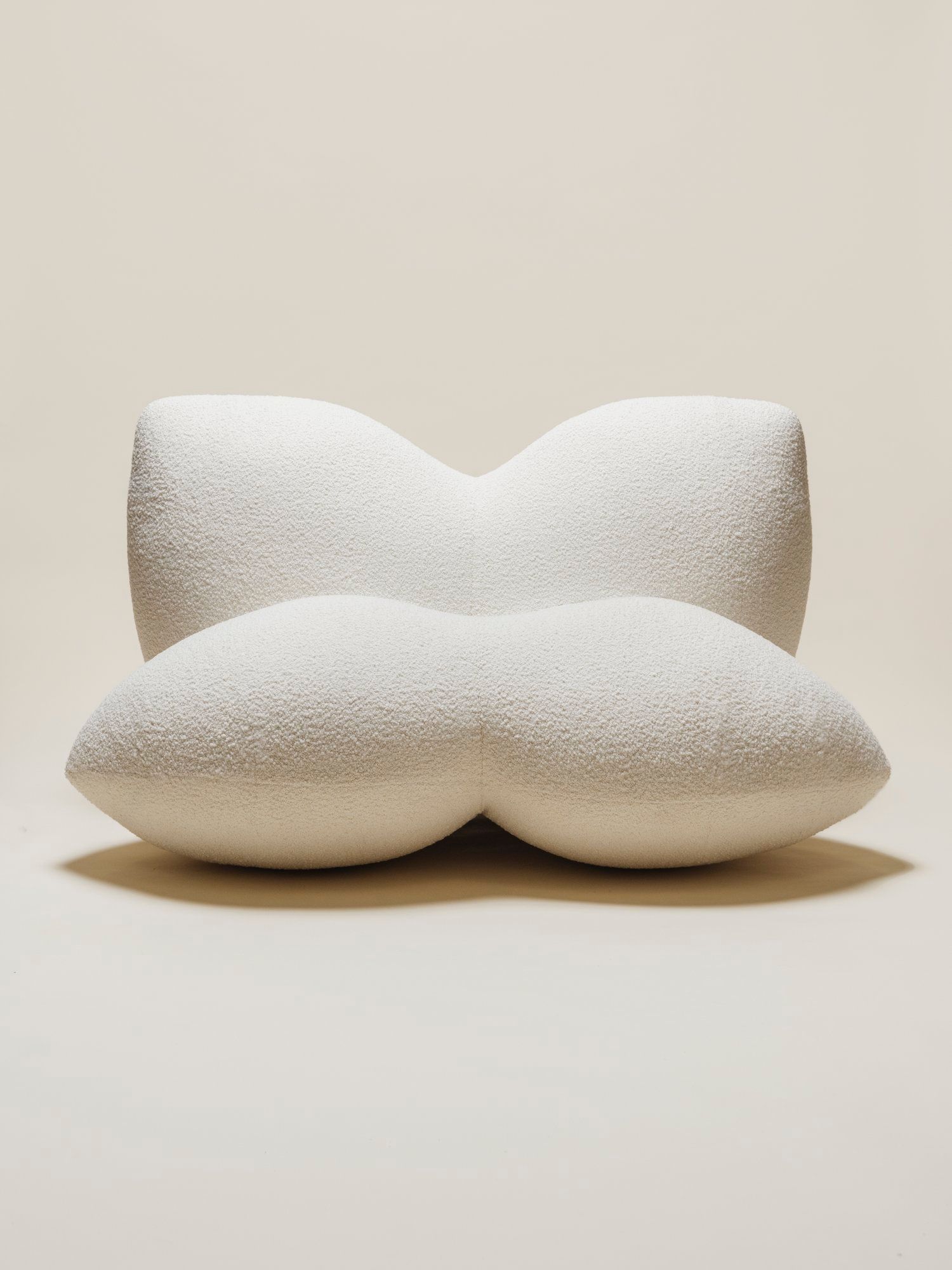 The Petal Chair by Studio Sam Klemick featuring soft, sculptural white upholstery with curved petal-like forms, blending comfort and organic design.