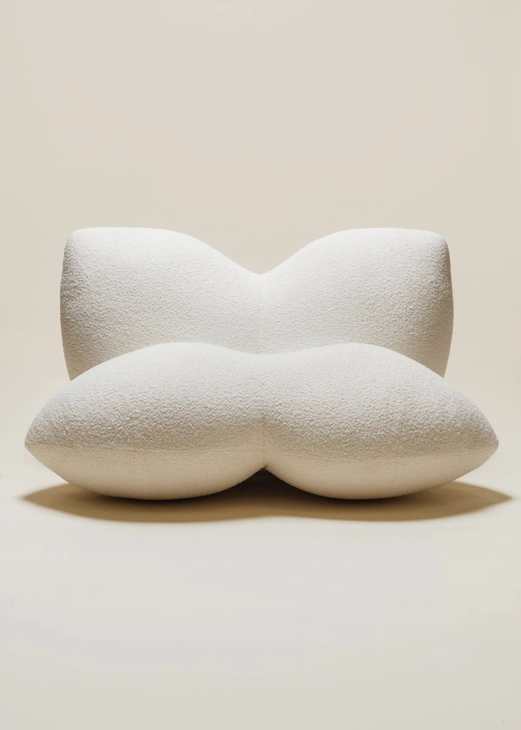 The Petal Chair by Studio Sam Klemick featuring soft, sculptural white upholstery with curved petal-like forms, blending comfort and organic design.