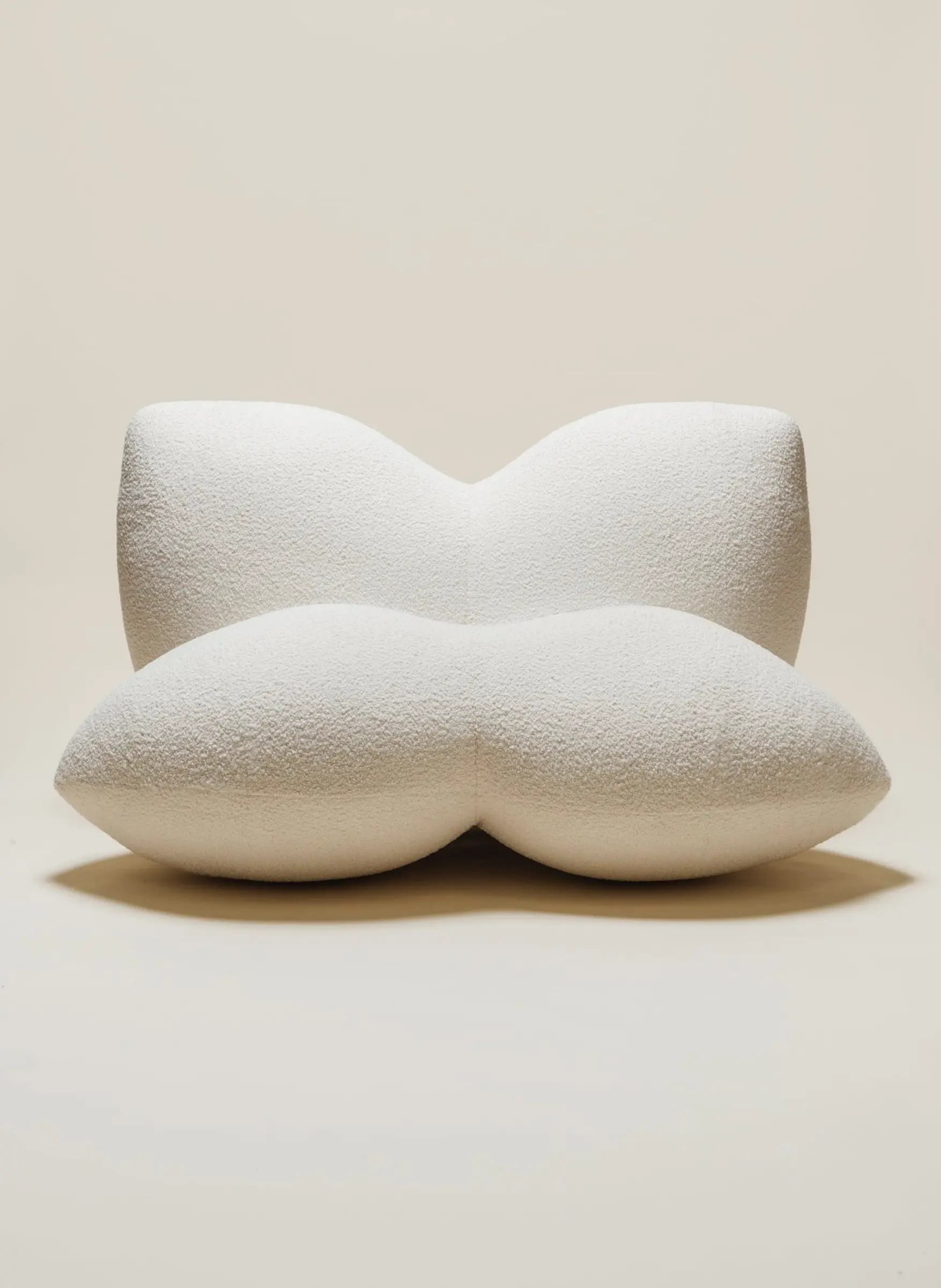 The Petal Chair by Studio Sam Klemick featuring soft, sculptural white upholstery with curved petal-like forms, blending comfort and organic design.