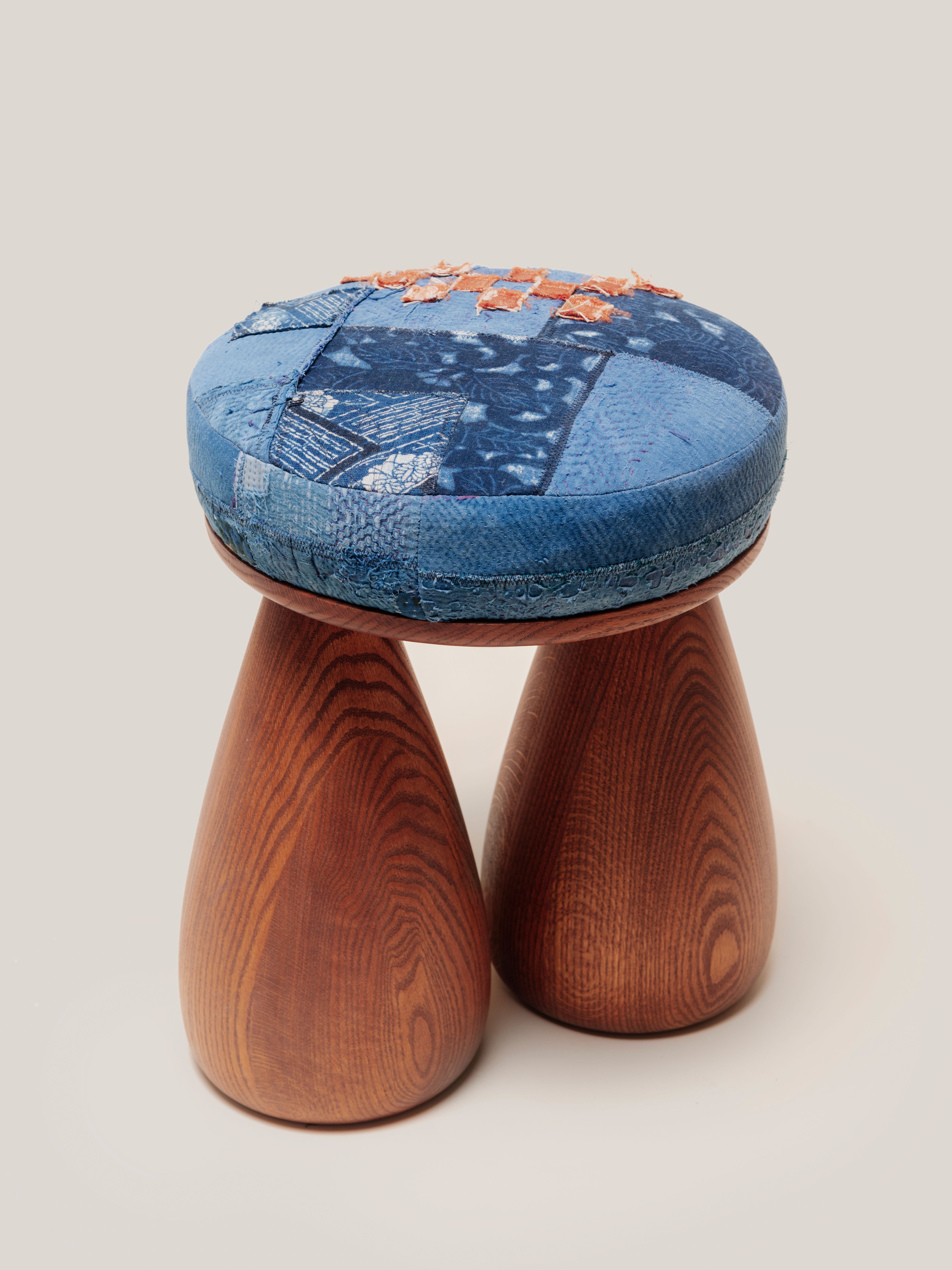 A plush stool and two legs in the shape of bell bottom jeans. 