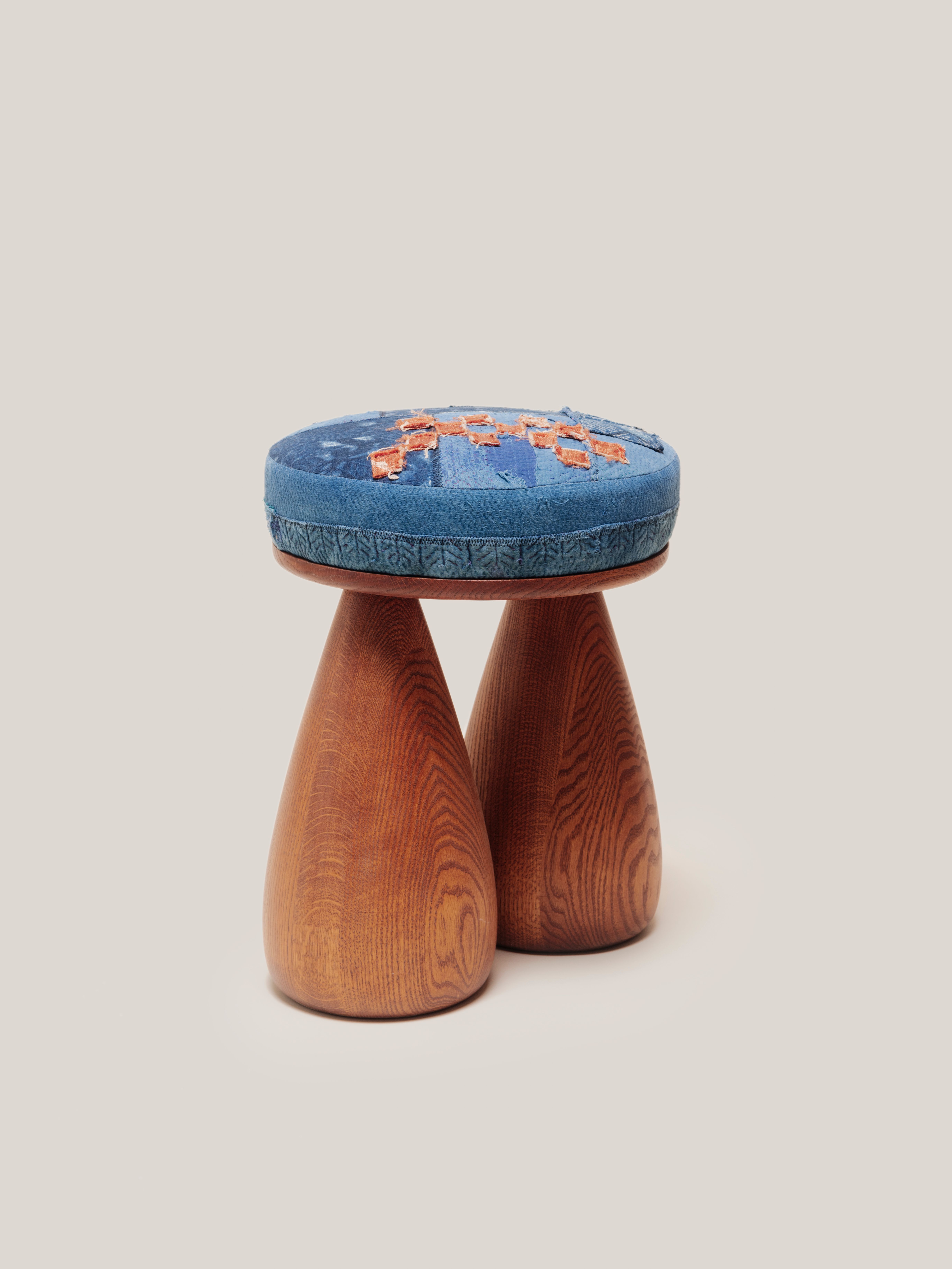 A plush stool and two legs in the shape of bell bottom jeans. 