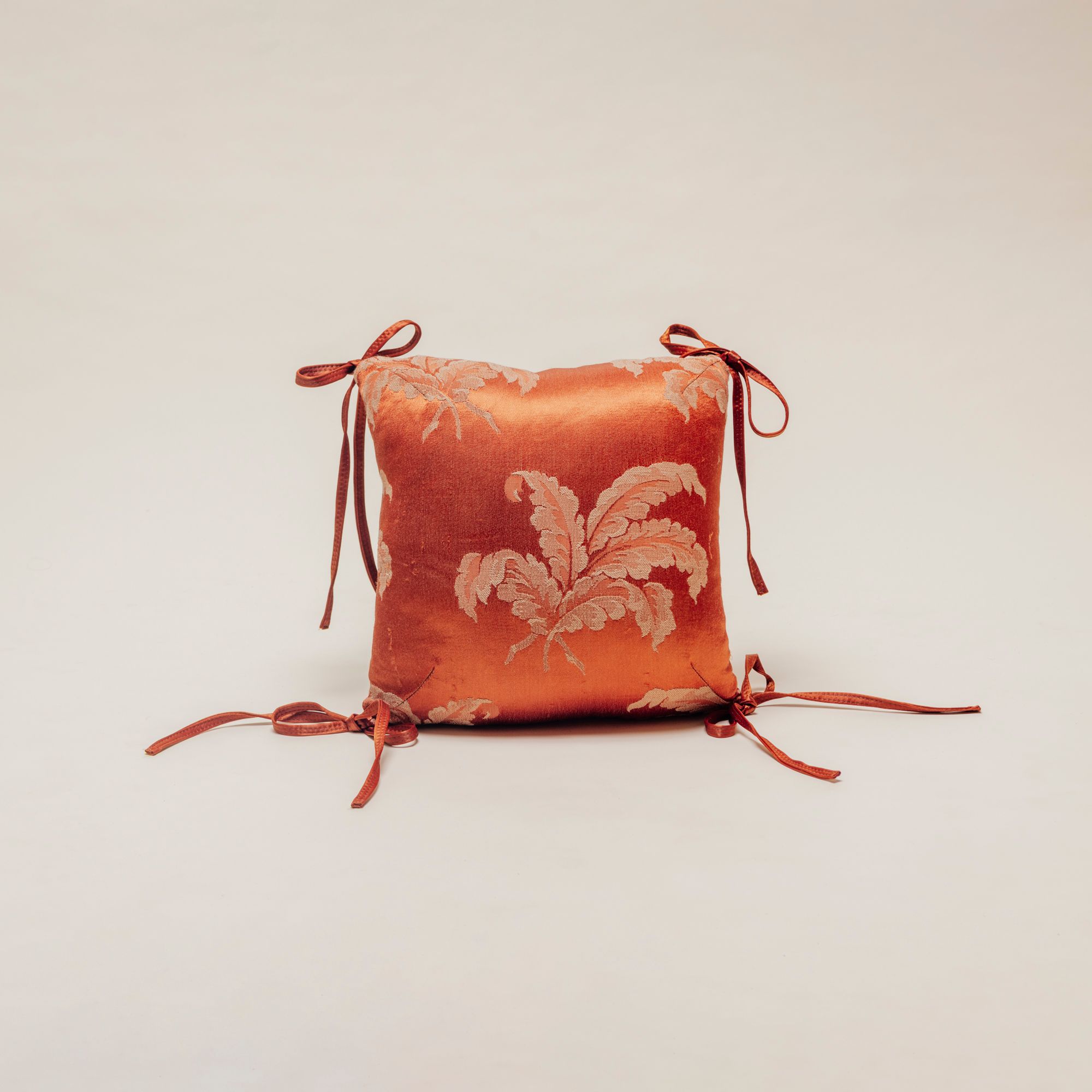 Orange silk pillow on clean background