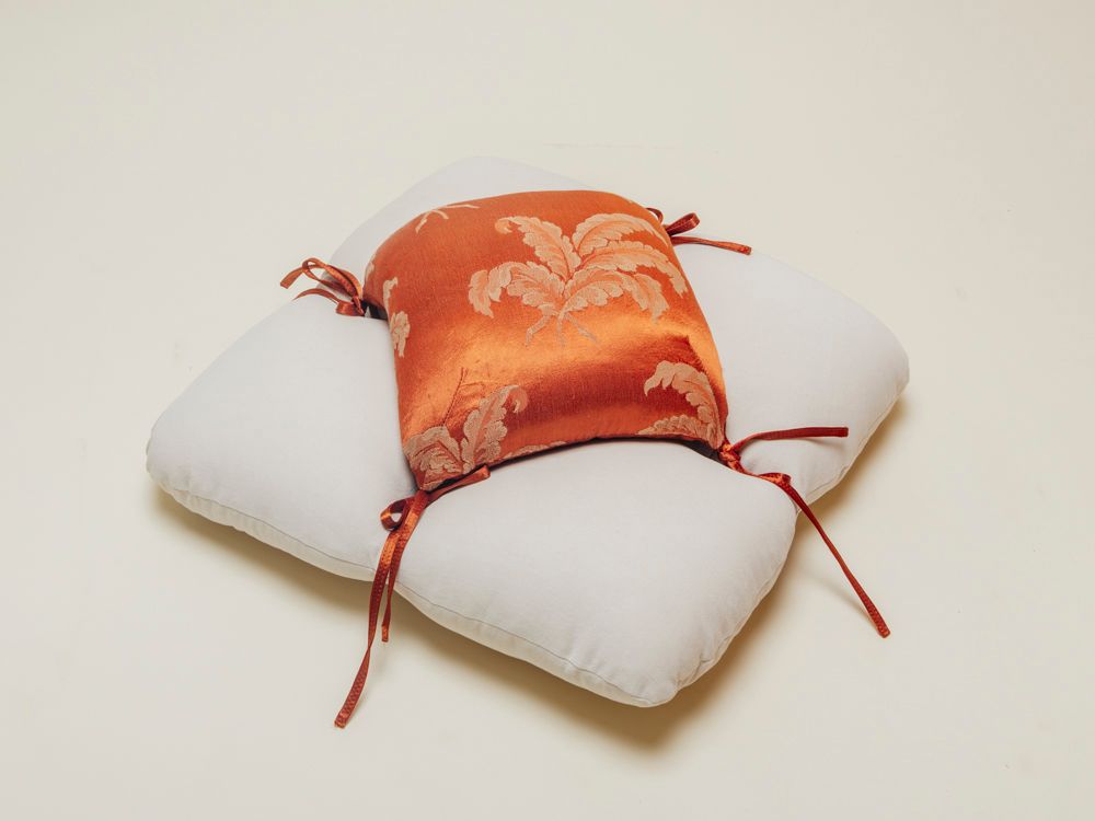 Petal floor cushion in an orange silk fabric and canvas base on clean background