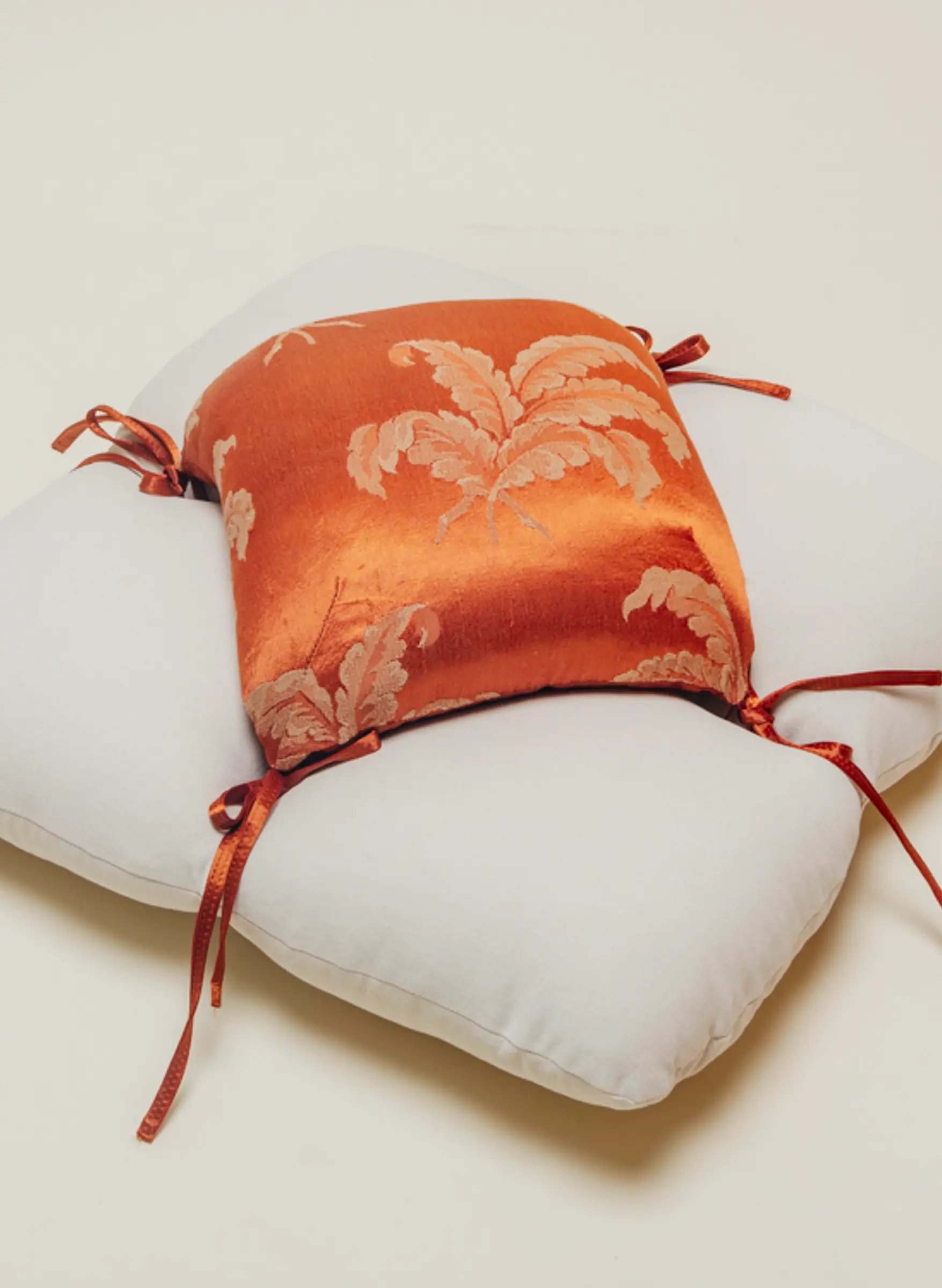 Petal floor cushion in an orange silk fabric and canvas base on clean background