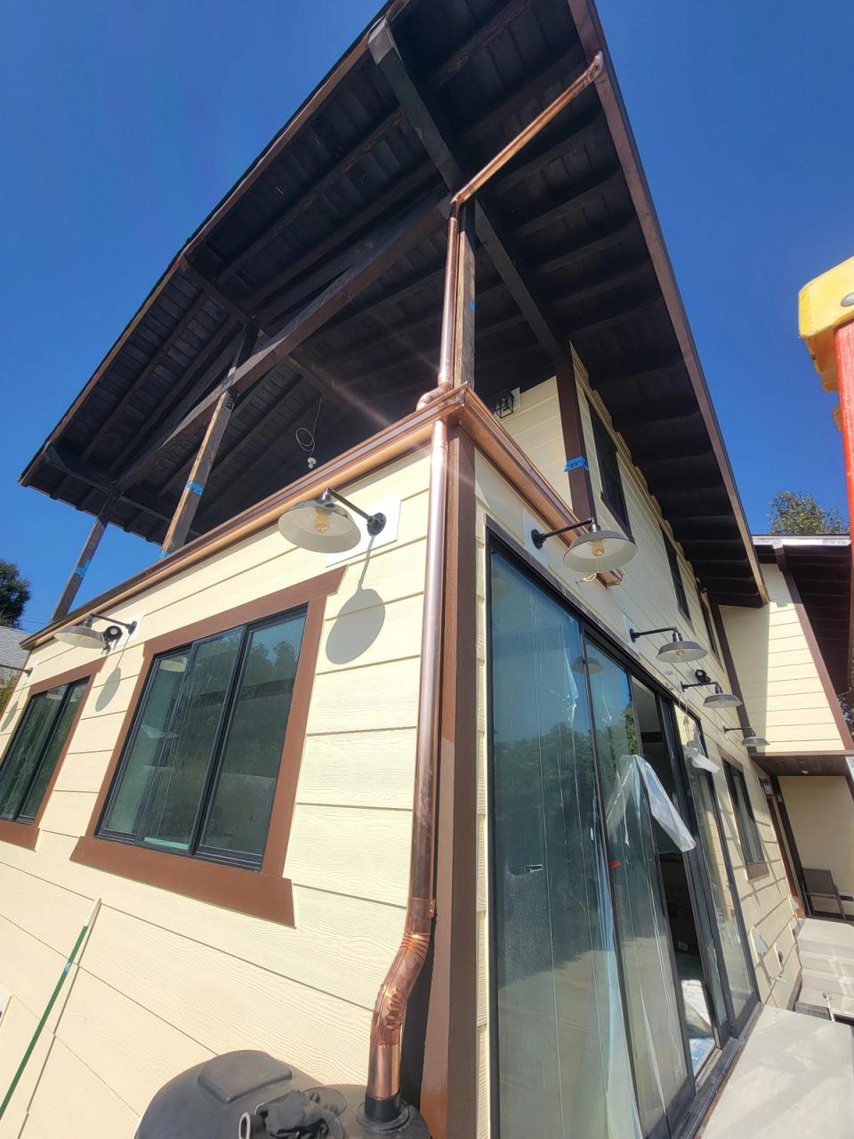 Copper gutter and downspout wrapping the corner of a modern craftsman home