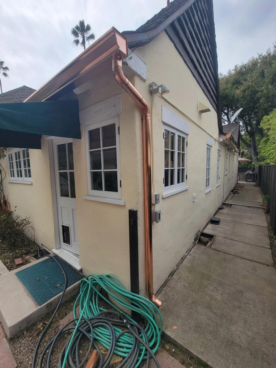 Copper gutter running the length of the eave on a cream-coloured cottage