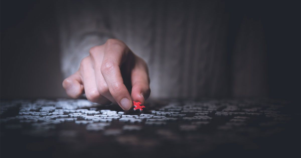 Hand holding red missing puzzle piece