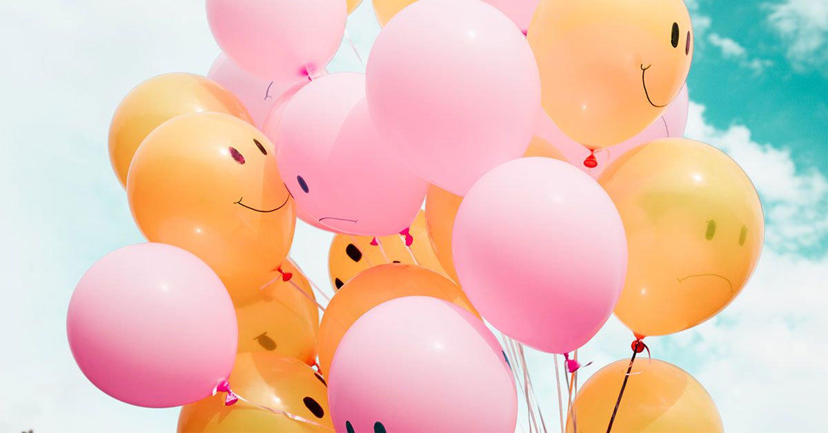 Bunch of balloons with smiling and frowning faces in clouds