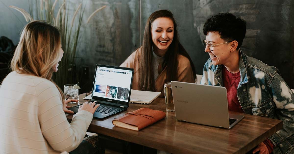 Team of women working on laptops in modern office space