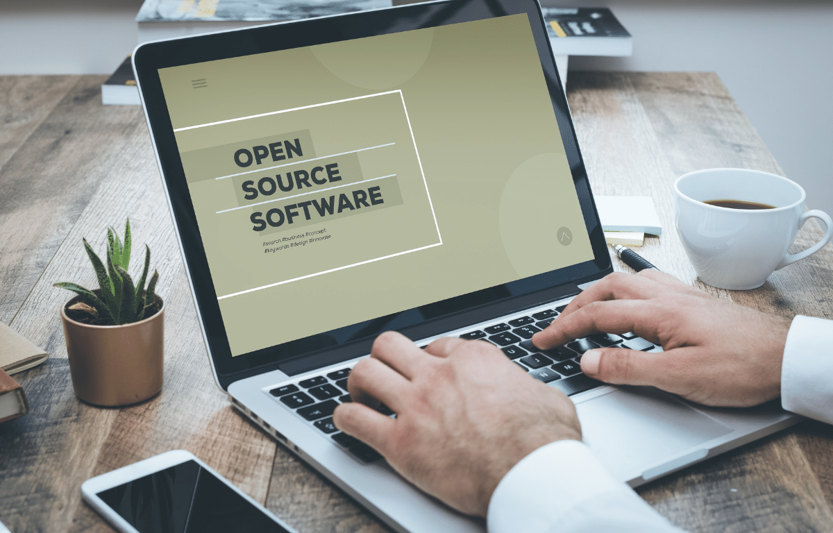 Professional typing on computer with screensaver that says open source software