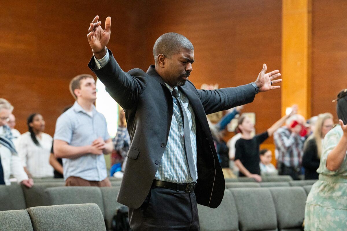 Lifting hands in worship at CLA