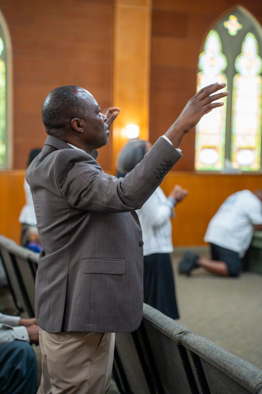 A man worshiping with hands raised at CLA
