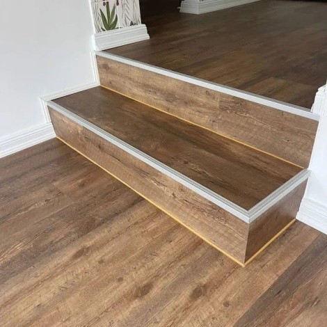 Vinylbodenverlegung mit neuen Sockelleisten sowie sanierter Treppe und modernisiertem Boden im Flur.