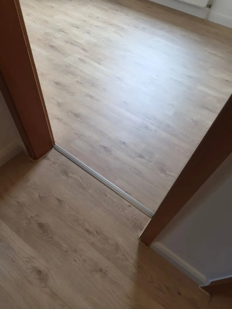 Türdurchgang zwischen zwei frisch renovierten Räumen mit sauberem Übergangsprofil in der Schwelle