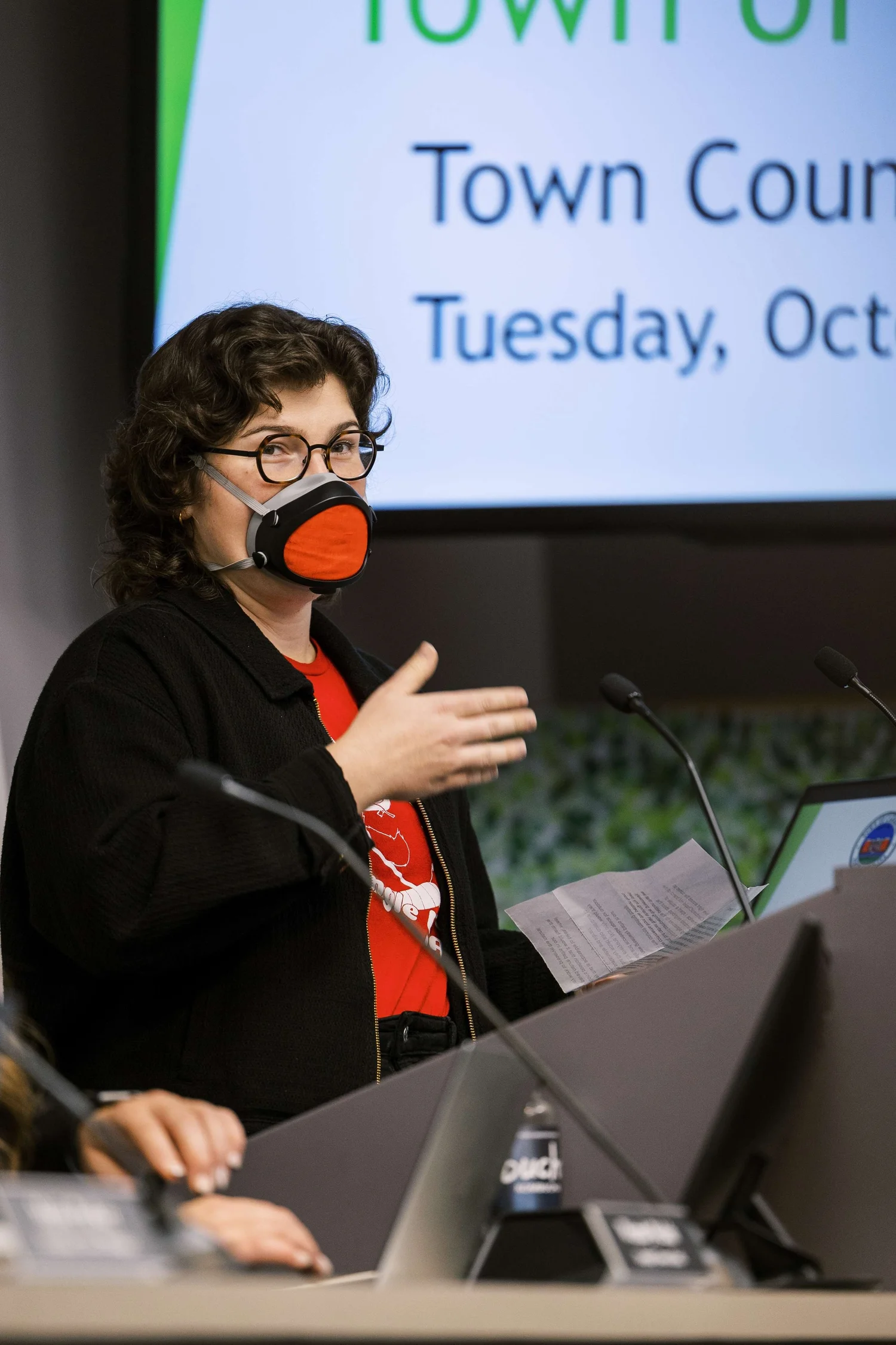 A person speaking into a microphone at the Carrboro Town Council
