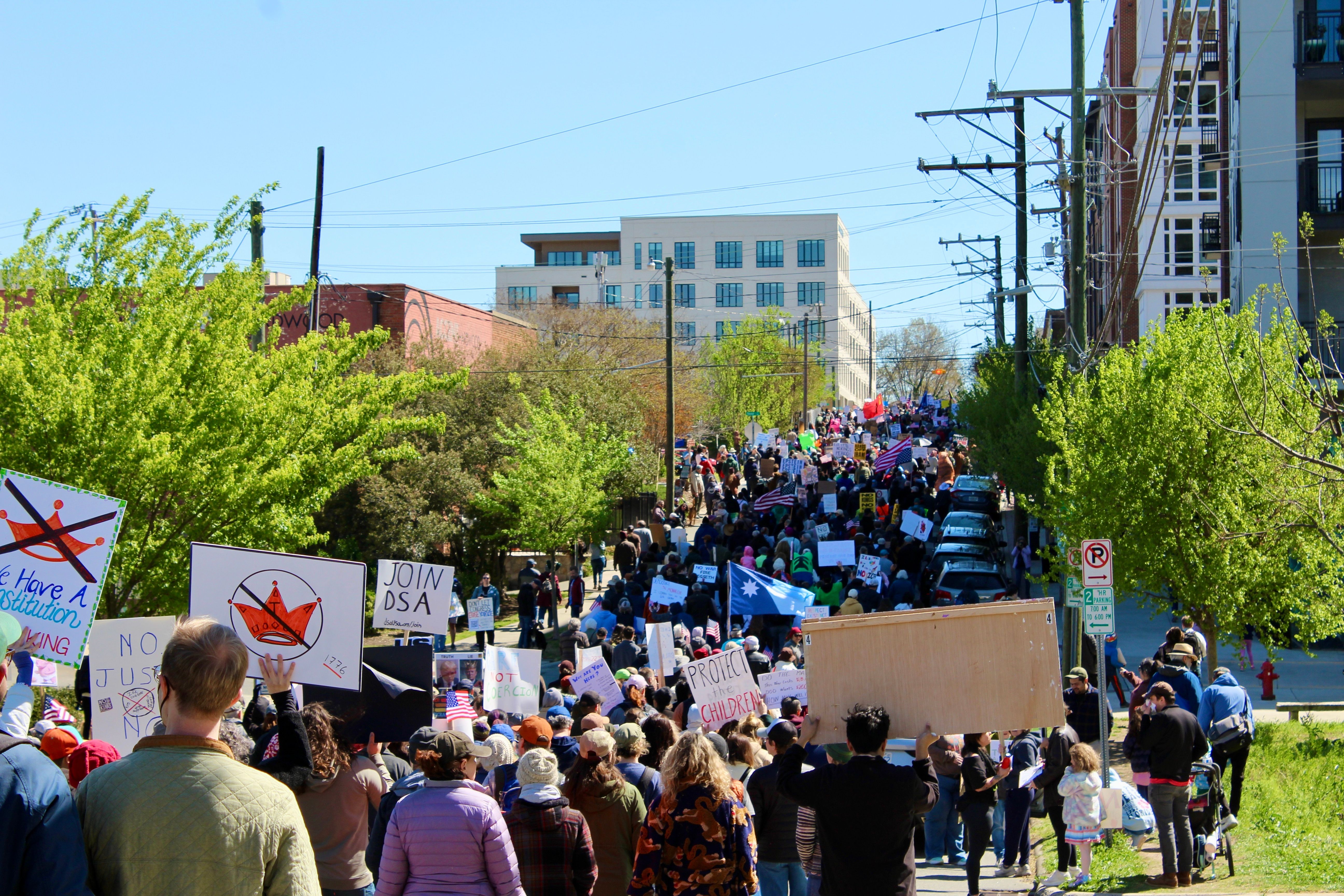 A crowd marching in downtown Durham, NC for a "No Kings" rally