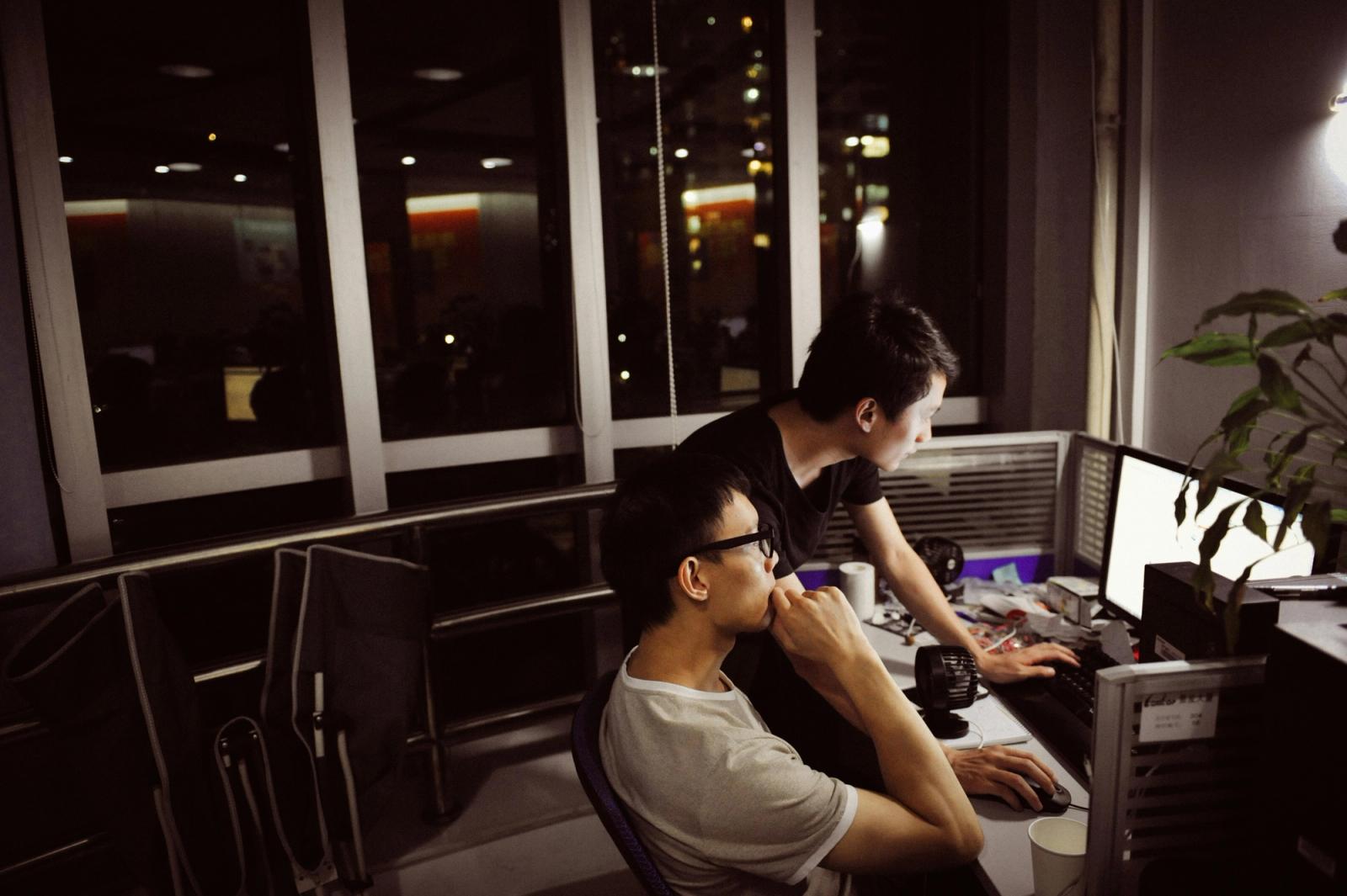 Dois profissionais analisam dados no computador à noite, fazendo um diagnóstico do marketing B2B