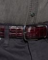 Black cherry crocodile belt close up on belt buckle around a man's waist