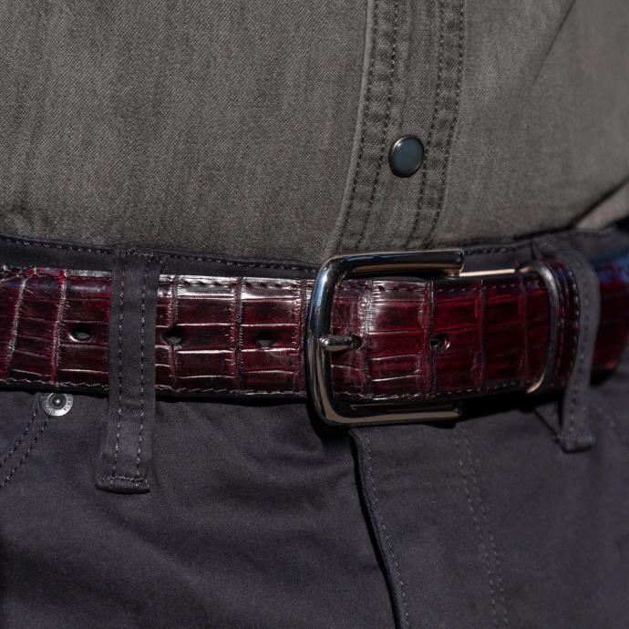 Black cherry crocodile belt close up on belt buckle around a man's waist