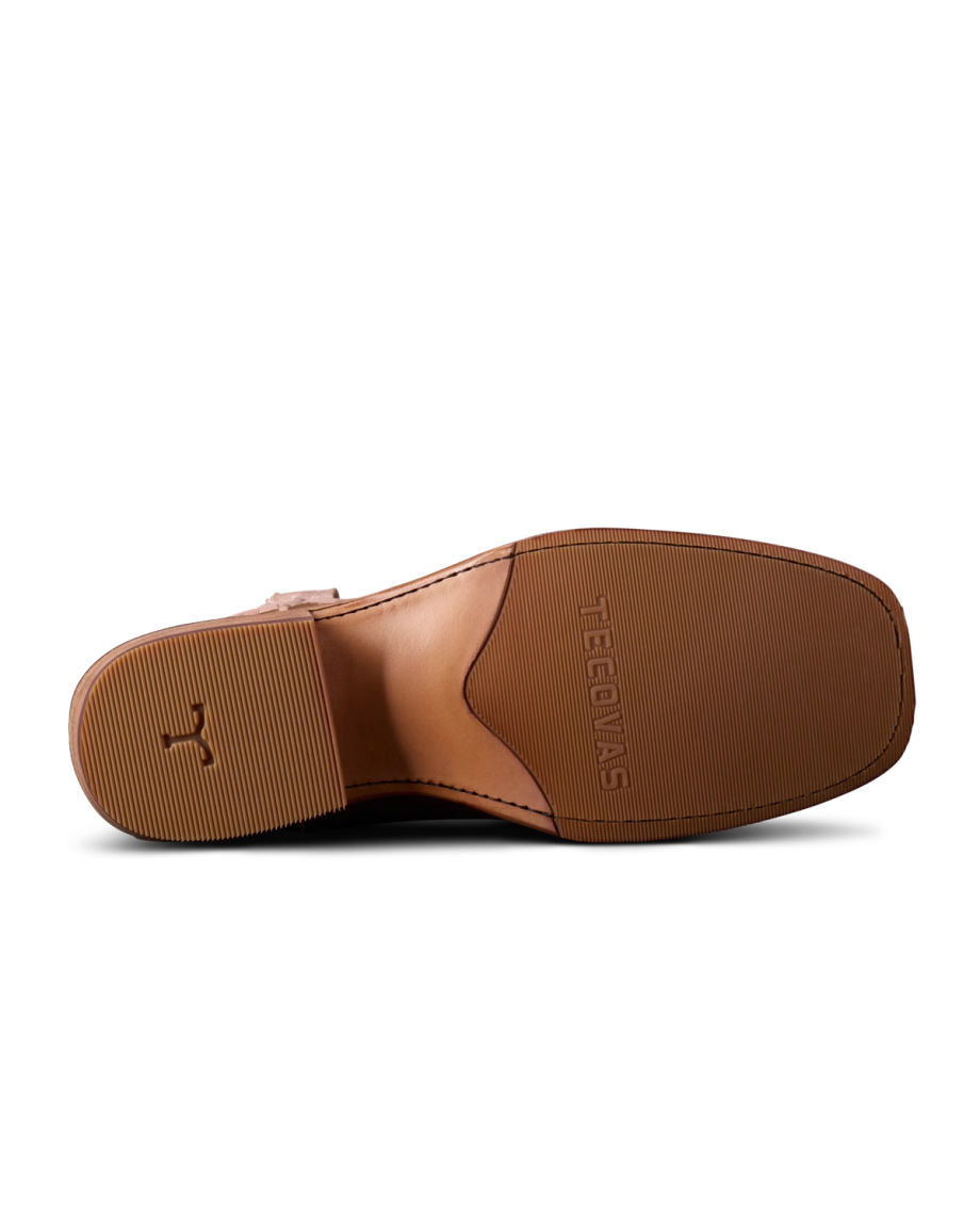 The image shows the sole of a brown leather shoe against a black background, featuring textured grip and branding.