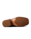 The image shows the sole of a brown leather shoe against a black background, featuring textured grip and branding.